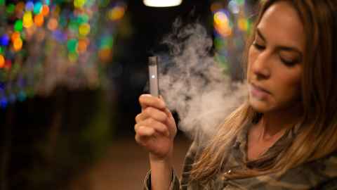 A young woman vaping.