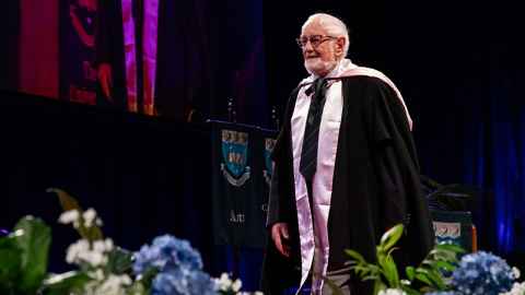 Emeritus Professor Alan Kirkness makes his way across the stage in the Arts graduation ceremony on 28 September 2022.