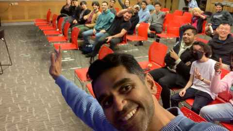 A man with a room full of people behind him