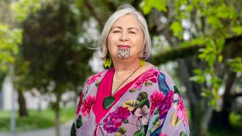 Dr Tess Moeke-Maxwell (Ngāi Tai ki Tāmaki, Ngāti Porou) in front of trees.