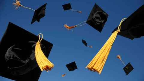 Graduation caps thrown in the air, with tassels flying.