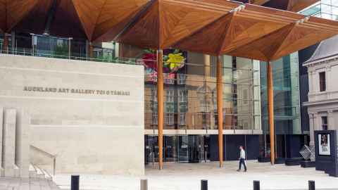 The exterior of the Auckland Art Gallery, with a single person heading towards the door.