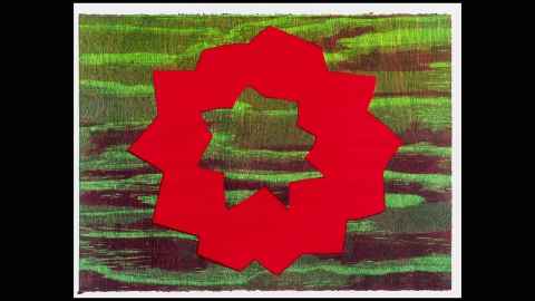 An artwork with the sea in the background and a red star shape over it.