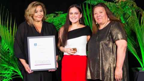 Three women, one holding a certificate.