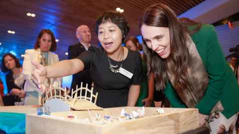 Hoa Pham and Jacinda Ardern in a crowded room.