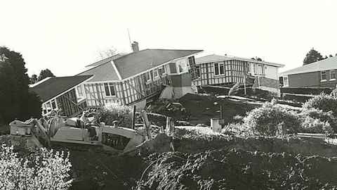 Houses falling off a hill, photographed in black and white.