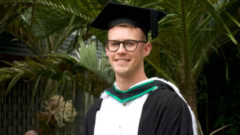 Tyler Kini in graduation regalia.