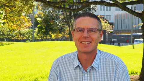 Professor Warwick Bagg with a park background.