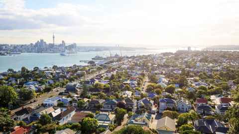 Auckland City from the North Shore, with suburban housing in the foreground, the CBD in the distance and the harbour in between.