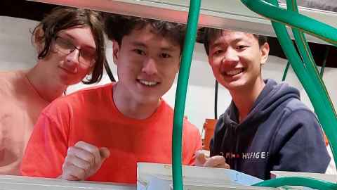 Three teenagers, smiling.