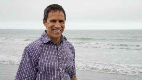 Dr Louis Tremblay, on a beach.
