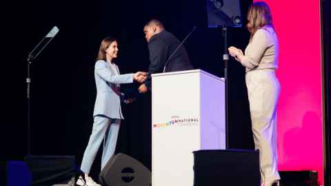 A young woman shaking hands with a man on a stage
