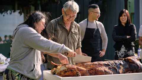 University of Auckland student Abigail Masengi cuts up a Chinese-style whole pig in Sik Fan Lah!