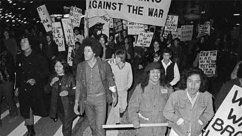 A black and white photo of a crowd of protesters with placards.
