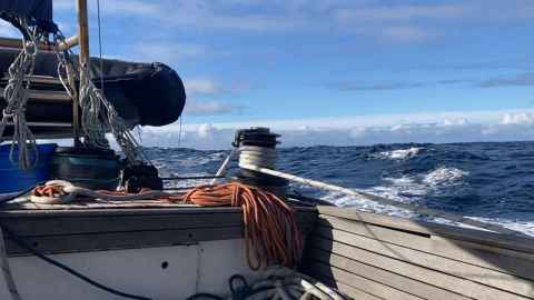 A view from the deck of Evohe, a sailing vessel, with blue waves beyond.
