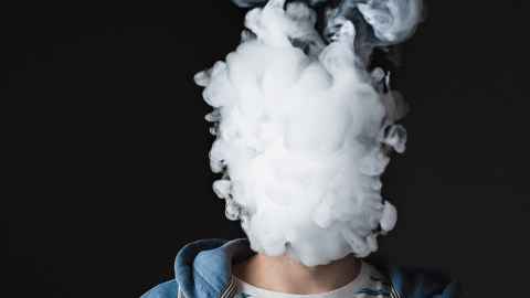 Cloud of vape smoke obscuring person's fact 