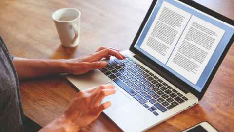 A person typing on a laptop computer.