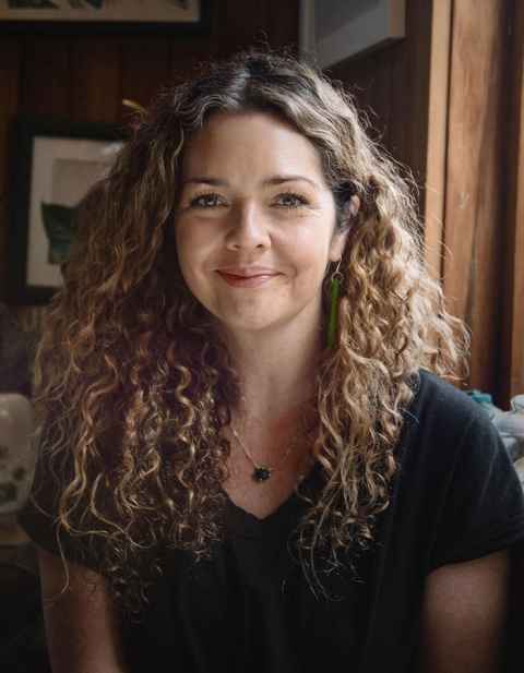 A curly-haired woman smiling.