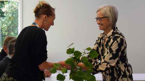 Whaea Pam Armstrong presents a kawakawa taonga to project manager Sophia de Fossard.