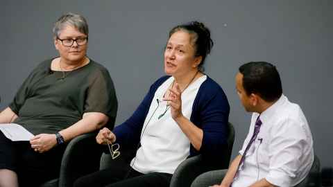 Associate Professor Matire Harwood sitting between two other people, talking.