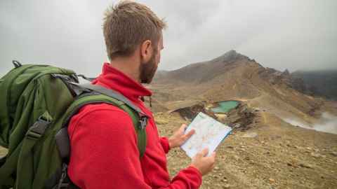 Man looking at map atop the Tongariro Crossing