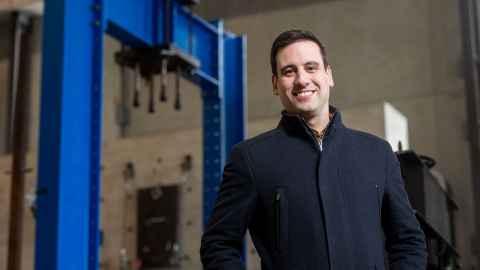 Dr Enrique del Rey Castillo from the Faculty of Engineering standing in front of a blue building beam.