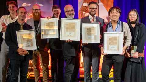 A group of people holding framed certificates.