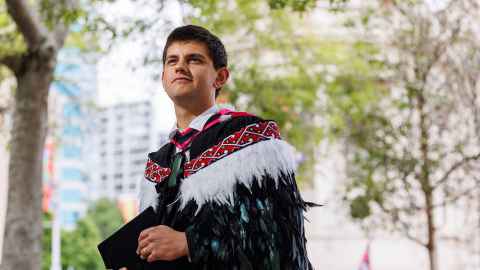 Isaac Samuels in graduation garb, including a korowai cloak.