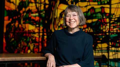 Dr Hilary Longhurst in front of a colourful mural.