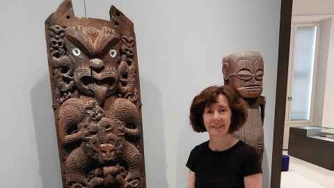 Professor Deidre Brown standing with recently found Kuwaha whakairo rakau, located at Ethnological Museum, Berlin.