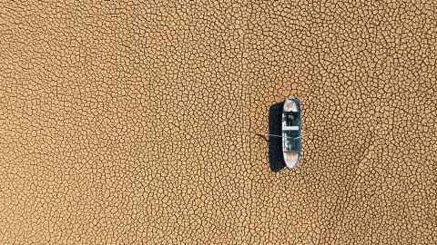Aerial view of boat marooned on dried cracked earth 