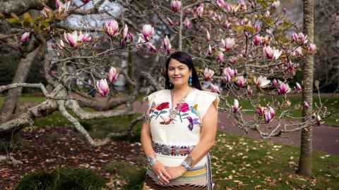 Sandra Yellowhorse in front of a magnolia tree.