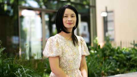 Head and shoulders of Dr Joanna Chu wearing a short-sleeved floral summer dress, outside B201 on Symonds Street.