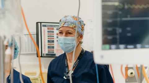 Esther in midwife scrubs in the delivery room with machines