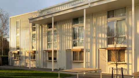 A two-storey social housing project bathed in autumnal light.