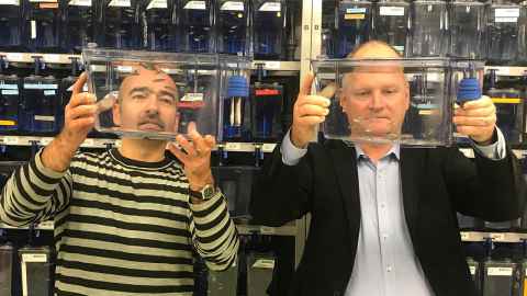 Associate Professor Christopher Hall and Associate Professor Guy Warman hold up zebrafish in tanks.