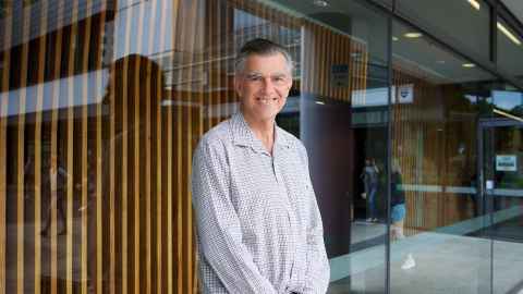 Dr Mark Thomas smiling outside the Faculty of Medical and Health Sciences.