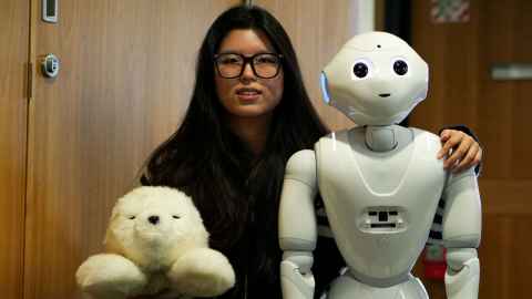 University of Auckland PhD researcher Yuan Gao with robots Paro and Pepper and a virtual human.