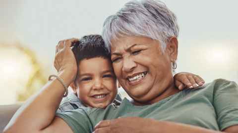 Older woman and younger child laughing together 