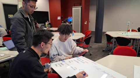 Hackathon participants Hao Yan (standing), Xincheng Li (left sitting) and Gavin Gao