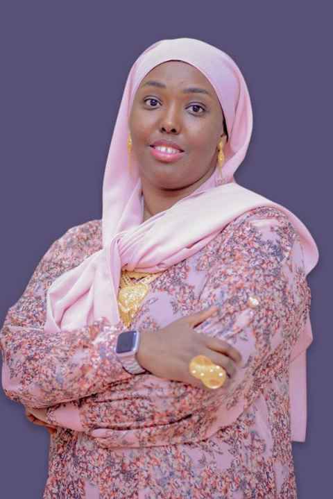 Image of Ayan Said wearing a pale pink silk headscarf and a pink floral long-sleeved dress.