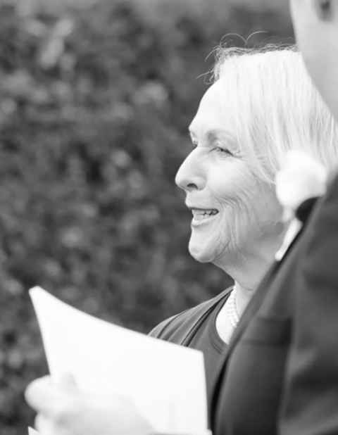 Side profile of Vivienne Gray, smiling and holding a piece of white paper.