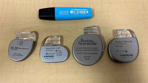 A selection of four traditional pacemakers and a pen to give indication of size