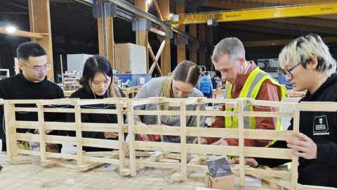 Students build a bowstring arch truss bridge from timber materials