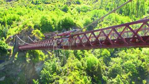 Kawarau gorge suspension bridge pictured amid a lush green landscape.