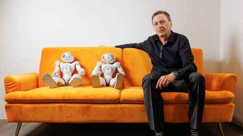 Witbrock on orange sofa with two robot doll things