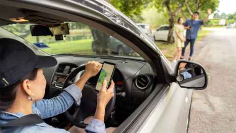 Uber driver arriving to pick up man waving phone