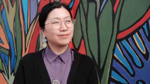 Dr Ying Wang against a colourful native leaf background.