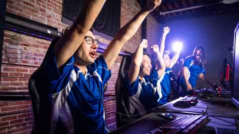 Winners of e-sports hold up arms in victory