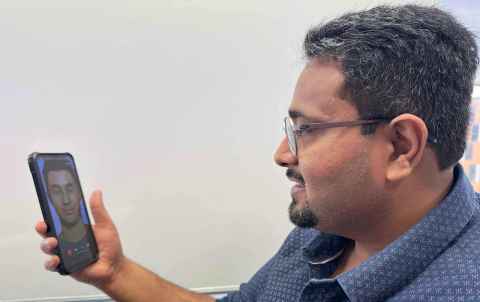 Kunal looks at his phone screen with an image of Toku Hoa